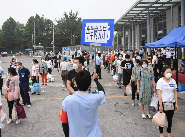Άτομα που τελείωσαν την καραντίνα περιμένουν το λεωφορείο στην αγορά τροφίμων Σινφαντί στην περιοχή Φενγκτάι του Πεκίνου, πρωτεύουσα της Κίνας, στις 11 Ιουλίου 2020. (φωτογραφία: Xinhua)