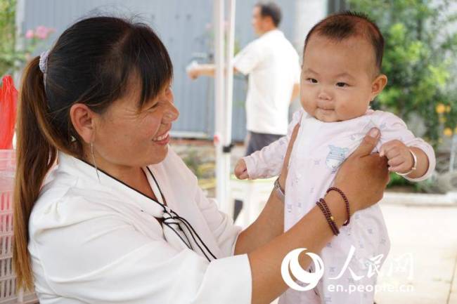 Ιδιοκτήτρια ενός κέντρου καλλιέργειας στην επαρχία Σανντόνγκ με το μωρό της. (Daily Daily Online / Li Qiaochu)