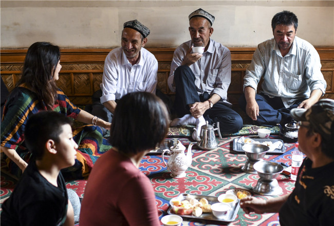 Τουρίστες συνομιλούν με τους ντόπιους σε ένα παντοπωλείο που υπάρχει από αιώνες στην Παλιά Πόλη του Κασγκάρ. [φωτογραφία / XINHUA]