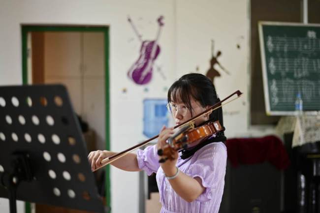 Μια μαθήτρια γυμνασίου από την κομητεία Τσονγκτζιάνγκ, στην επαρχία Γκουιτζόου της νοτιοδυτικής Κίνας, παίζει βιολί. [Φωτογραφία/ chinadaily]