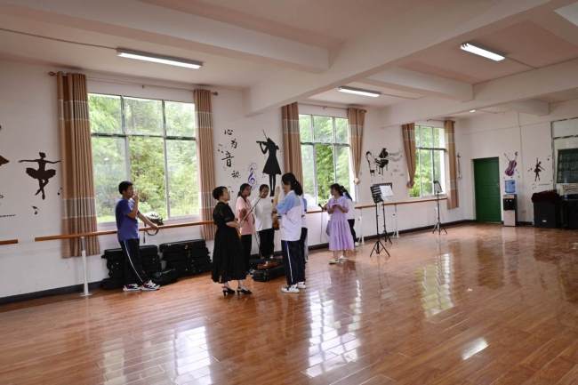 Στην τάξη μουσικής ενός γυμνασίου στην κομητεία Τσονγκτζιάνγκ, στην επαρχία Γκουιτζόου της νοτιοδυτικής Κίνας, ο δάσκαλος βιολιού (κέντρο) δίνει ένα μάθημα στους μαθητές. [Φωτογραφία / chinadaily]