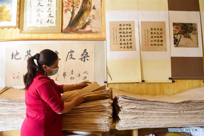 Τεχνίτρια τακτοποιεί τα φύλλα χαρτιού από φλοιό μουριάς στην κομητεία Μογιού του Χοτάν, που βρίσκεται στην Αυτόνομη Περιοχή Σιντζιάνγκ Ουιγκούρ της βορειοδυτικής Κίνας, την 1η Νοεμβρίου 2020. 