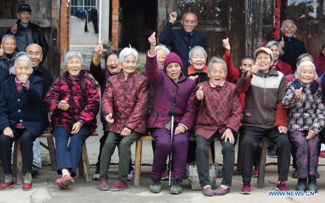 Χωρικοί ποζάρουν για μια ομαδική φωτογραφία στο χωριό Σανγκγουέι της περιοχής Γιοουλάν κοντά στην πρωτεύουσα Ναντσάνγκ, στην επαρχία Τζιανγκσί της ανατολικής Κίνας, στις 22 Νοεμβρίου 2020. (φωτογραφία / Xinhua)