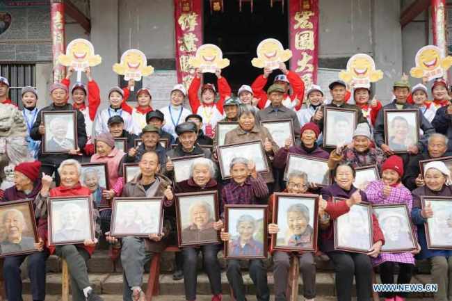 Οι χωρικοί και οι εθελοντές ποζάρουν μαζί για μια ομαδική φωτογραφία στο χωριό Σιαγουέι της περιοχής Γιοουλάν, κοντά στην πρωτεύουσα Ναντσάνγκ, στην επαρχία Τζιανγκσί της ανατολικής Κίνας, στις 22 Νοεμβρίου 2020.