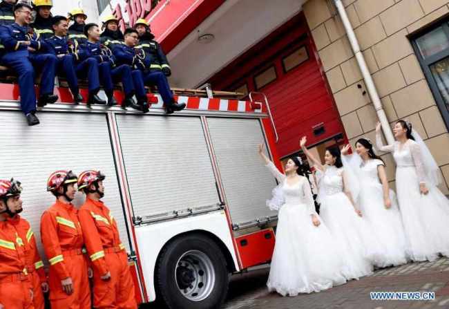 Πυροσβέστες φωτογραφίζονται με τις συζύγους τους μετά την τελετή των γάμων τους που έγινε στην Σαγκάη της ανατολικής Κίνας, στις 4 Ιανουαρίου 2021.