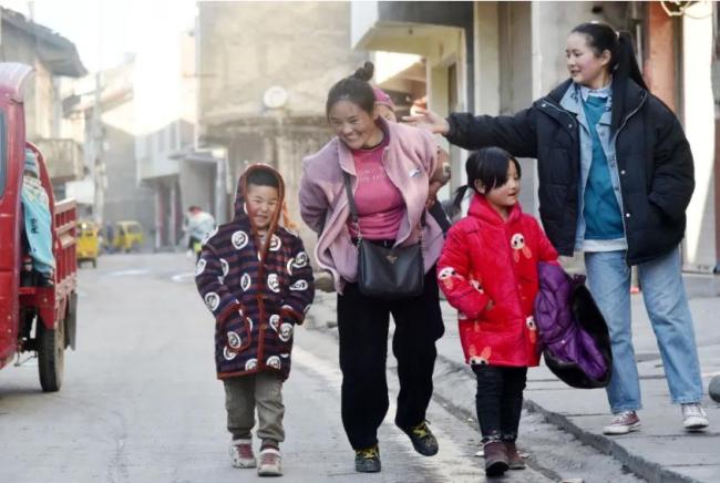 Η Μπαμού με τρία από τα παιδιά της, περπατούν σε έναν δρόμο, στις 22 Ιανουαρίου 2021. [Φωτογραφία / Xinhua]<br>