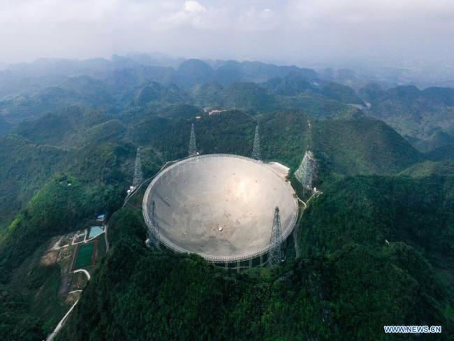 Η εναέρια φωτογραφία που τραβήχτηκε στις 28 Μαρτίου 2021 δείχνει το Σφαιρικό Τηλεσκόπιο ραδίου με Διάφραγμα Πεντακοσίων μέτρων (FAST, Five-hundred-meter Aperture Spherical radio Telescope) της Κίνας υπό συντήρηση στην επαρχία Γκουίτζοου της νοτιοδυτικής Κίνας. Το FAST έχει εντοπίσει πάνω από 300 πάλσαρ μέχρι στιγμής. Βρίσκεται σε ένα φυσικά βαθύ και στρογγυλό καρστικό κοίλωμα στην επαρχία Γκουίτζοου της νοτιοδυτικής Κίνας και ξεκίνησε επίσημα να λειτουργεί στις 11 Ιανουαρίου 2020. (φωτογραφία / Xinhua)