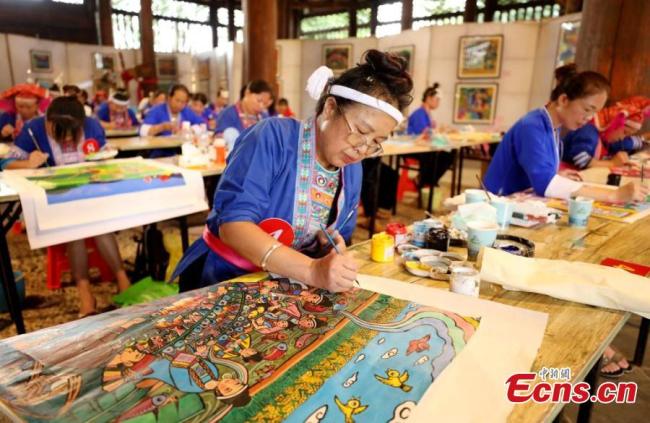 Οι γυναίκες της φυλής των Ντονγκ δημιουργούν πίνακες ζωγραφικής της αγροτικής τεχνικής Σαντζιάνγκ Ντονγκ σε διαγωνισμό που πραγματοποιήθηκε στο Λιουτζόου, στην αυτόνομη περιοχή Γκουανσί Τζουάνγκ της νότιας Κίνας στις 29 Ιουνίου 2021. (Φωτογραφία / Wu Lianxun)