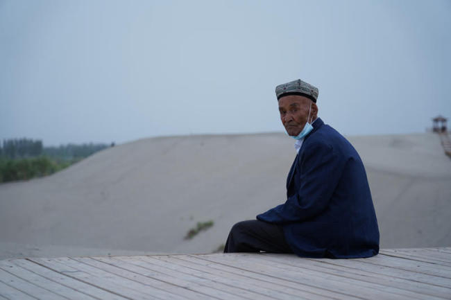 7. Ένας Ουιγούρος κάθεται στο νοτιοδυτικό τμήμα της ερήμου Τακλαμακάν στην πόλη Χοτάν, στην αυτόνομη περιοχή Σιντζιάνγκ Ουιγκούρ της βορειοδυτικής Κίνας, 22 Μαΐου 2021.