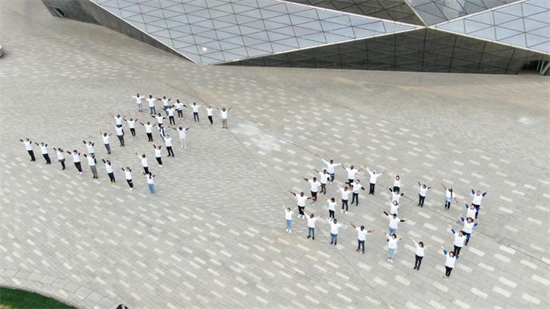 На площадке у театра «Шэнцзин» молодые люди построились в форме иероглифов «пять» и «четыре» (4 мая- День молодежи)
