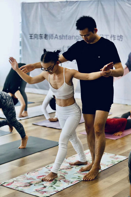 Wang Xiangdong drejton një entuziaste të yogës në klasën e tij në Pekin para shpërthimit të epidemisë