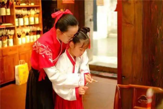 Jiang Peilan mëson një vajzë si të bëjë furcën e bukurshkrimit tradicional kinez/ foto nga agjencia Xinhua