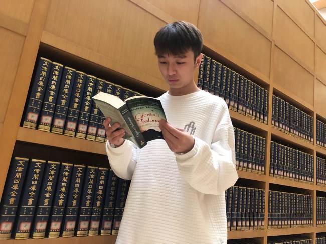 Një student kinez po lexon librin në gjuhën shqipe