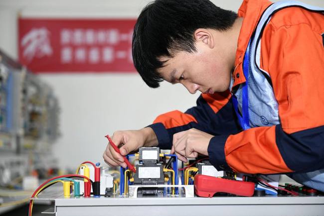 Foto: Një konkurrent merr pjesë në konkursin e inxhinierisë elektrike gjatë një konkurrimi për aftësi profesionale në Prefekturën Autonome të Kombësive Buyei dhe Miao Qianxinan, në provincën Guizhou të Kinës Jugperëndimore, 23 shtator 2021. /Xinhua