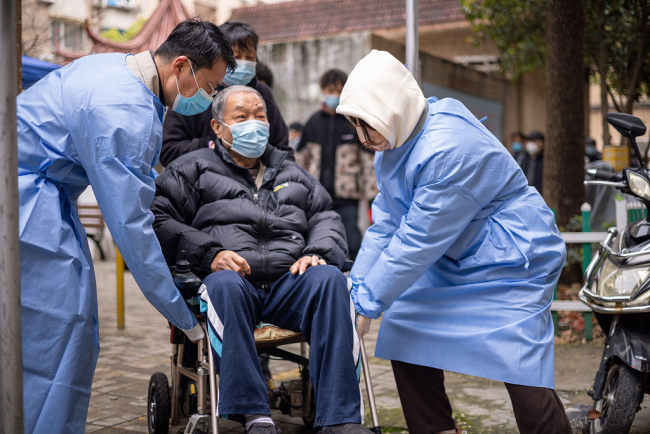Punonjësit mjekësorë ndihmojnë një të moshuar të bënte test nukleik, 18 mars,Shangai