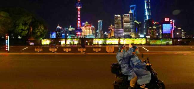 Punonjësit mjekësorë udhëtojnë përgjatë Bundit në Shangai pasi mbarojnë punën vonë natën.Foto nga China Daily