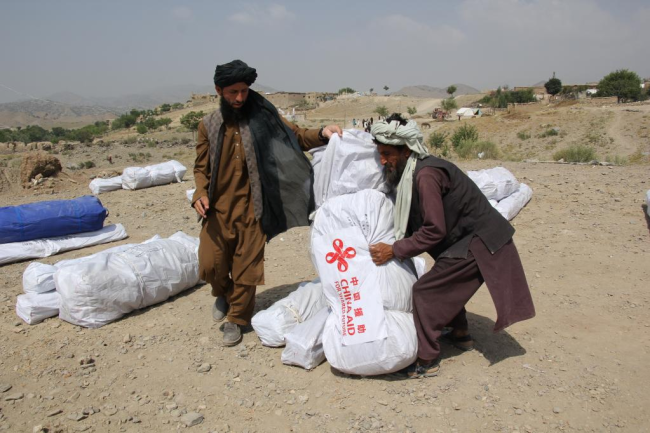 Një burrë afgan mbajti furnizimin shpëtimtar të dhuruar nga Kina pas tërmetit, më 2 korrik 2022 në provincën Paktika të Afganistanit/ Xinhua