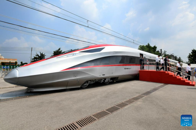 Foto e bërë më 5 gusht 2022, që tregon një tren elektrik udhëtarësh me shpejtësi të lartë, i përshtatur për hekurudhën me shpejtësi të lartë Xhakartë-Bandung, duke u ngarkuar në një anije në portin Qingdao të provincës Shandong të Kinës Lindore. Një numër trenash udhëtarësh dhe një tren inspektimi do të transportohen në Indonezi, duke shënuar përparim të rëndësishëm në ndërtimin e kësaj hekurudhe, një projekt historik në kuadër të nismës "Një brez, një rrugë". (Foto nga Li Ziheng/Xinhua)