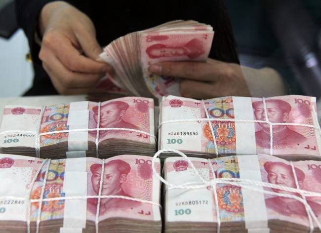 Bankovní personál počítá bankovky čínské měny Renminby (yuanů) v bance v kraji Tancheng ve městě Linyi ve východočínské provincii Shandong. [Photo/Xinhua]