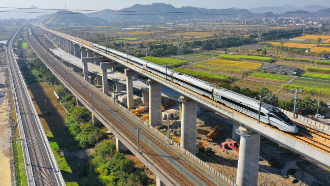Snímek: Vlak je ve zkušebním provozu na vysokorychlostní železnici Hangzhou-Taizhou, Wenling (Wen-ling) v provincii Zhejiang, Čína; 26. listopadu 2021./ CFP