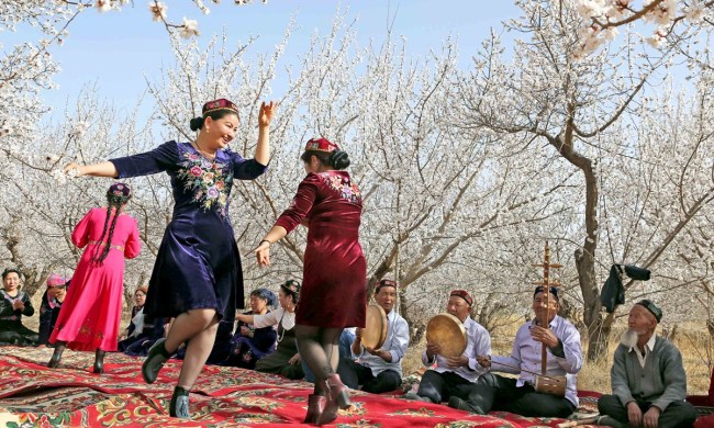 Lidé na tradičním shromáždění ujgurské komunity Meshrep v městě Hami v Xinjiangu. Photo: IC