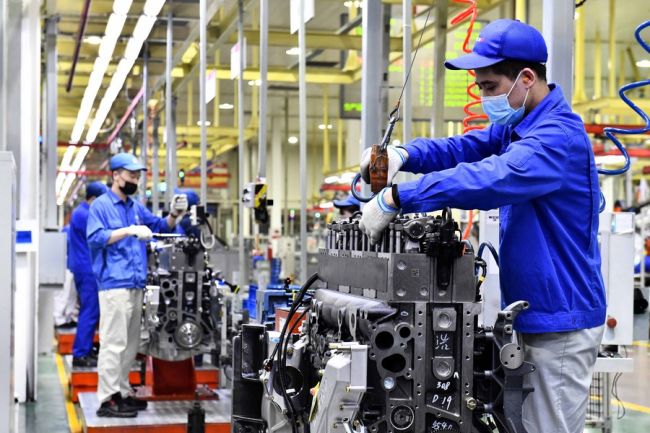 Pracovníci na montážní lince továrny Weichal Power Co., Ltd. vyrábí motory ve městě Weifan ve východočínské provincii Shandong, 22. dubna 2021. (Photo/Xinhua)