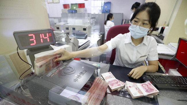 Snímek: Bankovní pokladnice počítá yuany v bance v provincii Shanxi (Šan-si) na severozápadě Číny; 6. srpna 2020. /CFP