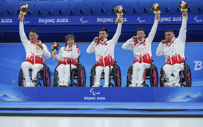 Snímek: Čínský tým pózoval 12. března 2022 se svými zlatými medailemi poté, co zvítězil ve finále curlingu na vozíku proti Švédsku 8:3 v Národním centru vodních sportů v Pekingu na Zimních paralympijských hrách v Pekingu 2022. /CFP