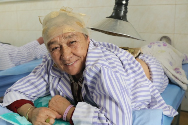 Die 70-järhige Rentnerin Zuohere Yibulayimu vertraut der TCM-Behandlung sehr. Sie wird regelmäßig hier mit Akkupunktur behandelt und unterhält sich gerne mit Maierhaba.