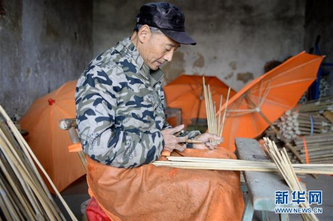 Wang Yansong stellt die Rippen für Wachstuchschirme im Guomin Werk her.