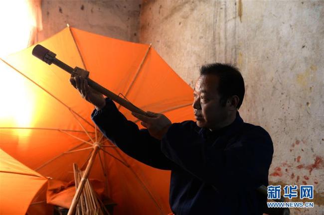 Zheng Guomin fertigt den Griff für einen Wachstuchschirm.