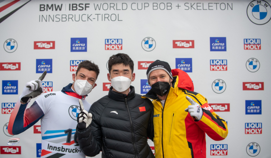 Foto: Geng Wenqiang (M) posiert mit Matt Weston aus Großbritanniens (L) und Christopher Grotheer aus Deutschland (R) bei der Siegerehrung im Skeleton der Herren während des IBSF-Weltcups in Igls, Österreich, am 26. November 2021. /CFP