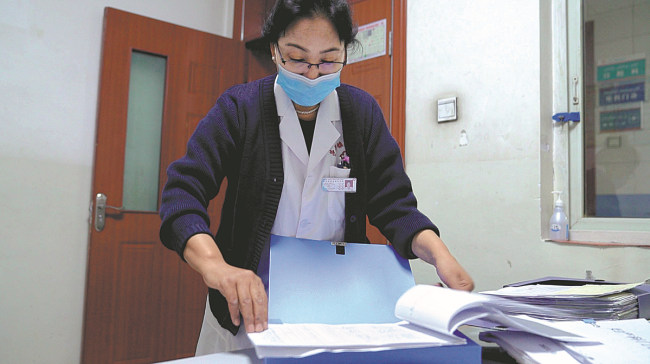 Η Αρεζγκούλ Τουρσούν ελέγχει τους φακέλους των ασθενών. [CHINA DAILY]