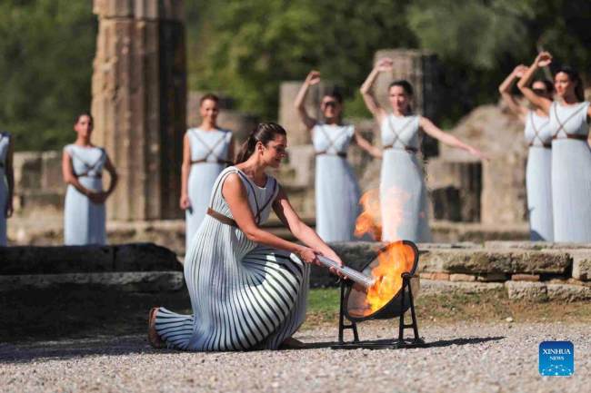 Η Ελληνίδα ηθοποιός Ξανθή Γεωργίου, στο ρόλο της αρχαίας Ελληνίδας πρωθιέρειας, ανάβει την δάδα κατά τη διάρκεια της τελετής αφής της Ολυμπιακής φλόγας για τους Χειμερινούς Ολυμπιακούς Αγώνες του Πεκίνου 2022, στην αρχαία Ολυμπία, Ελλάδα, 18 Οκτωβρίου 2021. (φωτογραφία / Xinhua)