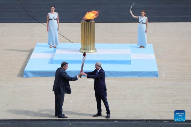Ο Γιου Ζαϊτσίνγκ (δεξιά), ειδικός αντιπρόσωπος και αντιπρόεδρος της Οργανωτικής Επιτροπής των Χειμερινών Ολυμπιακών και Παραολυμπιακών Αγώνων του Πεκίνου 2022, λαμβάνει την δάδα με την Ολυμπιακή Φλόγα από τον Πρόεδρο της Ελληνικής Ολυμπιακής Επιτροπής Σπύρο Καπράλο κατά την τελετή παράδοσης της Ολυμπιακής Φλόγας για τους Χειμερινούς Ολυμπιακούς Αγώνες του Πεκίνου 2022 στο Παναθηναϊκό Στάδιο στην Αθήνα, Ελλάδα, 19 Οκτωβρίου 2021. (φωτογραφία / Xinhua)