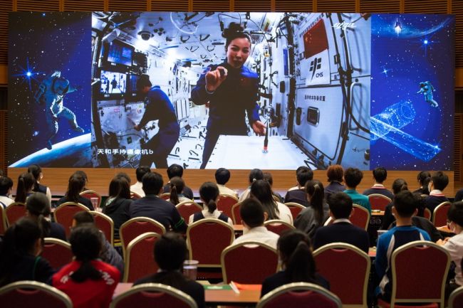 Η φωτογραφία που τραβήχτηκε στο Μακάο της νότιας Κίνας στις 9 Δεκεμβρίου 2021 δείχνει την αστροναύτισσα Γουάνγκ Γιαπίνγκ, μέλος του πληρώματος Shenzhou-13 να δίνει μια ειδική διάλεξη στον διαστημικό σταθμό της Κίνας μέσω σύνδεσης βίντεο. (φωτογραφία/Xinhua)
