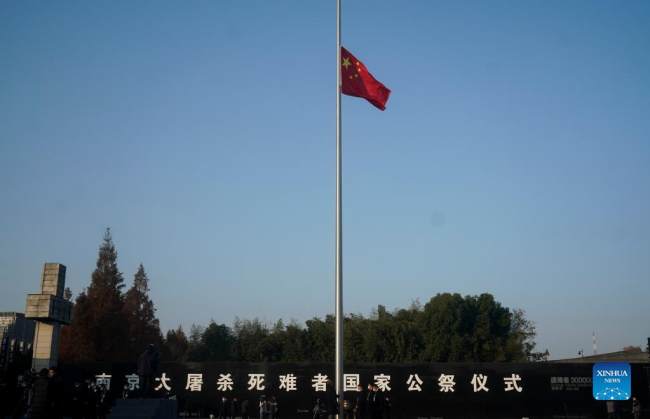 Η εθνική σημαία της Κίνας κυματίζει μεσίστια πριν από την εθνική τελετή μνήμης για τα θύματα της σφαγής στη Ναντζίνγκ στην Αίθουσα Μνήμης των Θυμάτων της Σφαγής της Ναντζίνγκ από τους Ιάπωνες Εισβολείς στη Ναντζίνγκ, πρωτεύουσα της επαρχίας Τζιανγκσού της ανατολικής Κίνας, 13 Δεκεμβρίου 2021. (φωτογραφία/Xinhua)