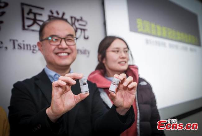 Ο Τζανγκ Λιντσί (αριστερά), καθηγητής στην Ιατρική Σχολή του Πανεπιστημίου Τσινγκχουά, παρουσιάζει δύο δείγματα κατά τη διάρκεια συνέντευξης Τύπου στο Πανεπιστήμιο Τσινγκχουά, Πεκίνο, 9 Δεκεμβρίου 2021. (Φωτογραφία: China News Service)