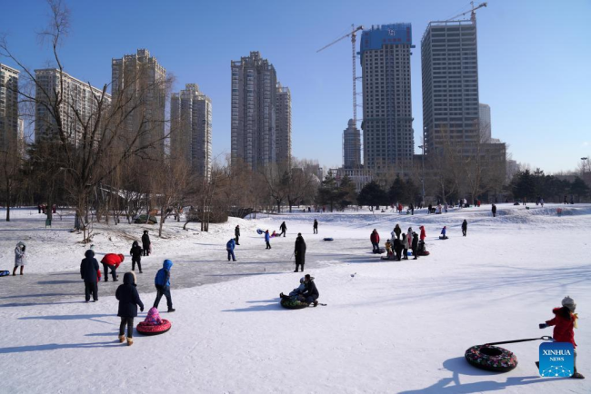 Κόσμος παίζει στον πάγο σε ένα πάρκο στο Χαρμπίν, στην επαρχία Χεϊλονγκτζιάνγκ της βορειοανατολικής Κίνας, 3 Ιανουαρίου 2022. (Xinhua/Wang Jianwei)