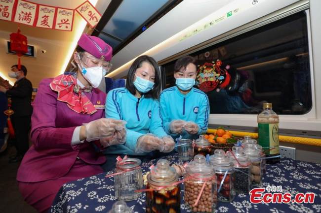Επιβάτες (乘客 Chéngkè) και συνοδοί τρένων (乘务员Chéngwùyuán ) στο Fuxing EMU (C5980) φτιάχνουν σκόρδα Λαμπά στο Μπιτζιέ, στις 9 Ιανουαρίου 2022. (Φωτογραφία: China News Service)