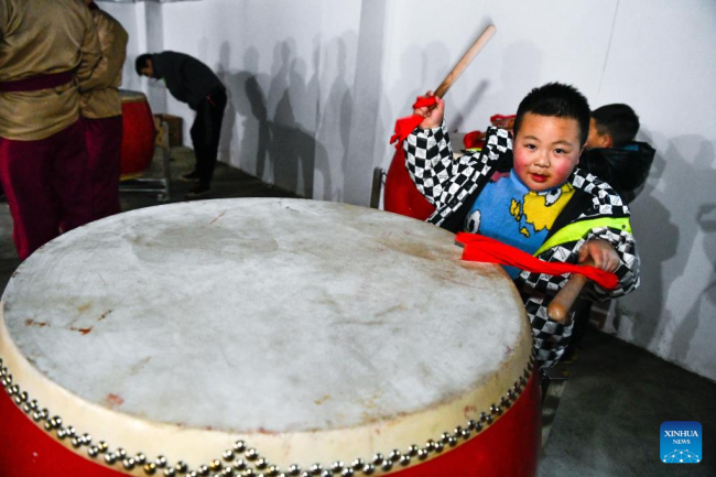 Ένα παιδί παίζει ένα τύμπανο στην κομητεία Λονγκσάν, της επαρχίας Γκουιτζόου της νοτιοδυτικής Κίνας, 7 Φεβρουαρίου 2022.