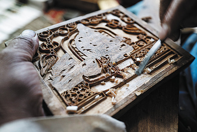 Ο Κάρμα Τσόντρακ δουλεύει σε ένα κομμάτι ξύλο στο εργαστήριό του.[Φωτογραφία/Xinhua]