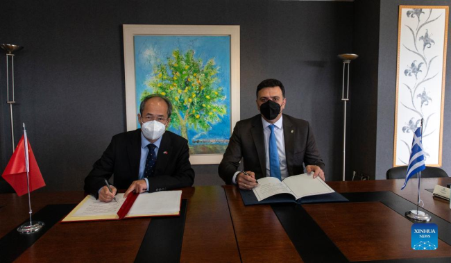Ο Έλληνας Υπουργός Τουρισμού Βασίλης Κικίλιας (δεξιά) και ο Πρέσβης της Κίνας στην Ελλάδα Σιάο Τζουντζένγκ υπογράφουν έγγραφα στην Αθήνα, Ελλάδα, στις 14 Μαρτίου 2022. (φωτογραφία: Xinhua/Marios Lolos)