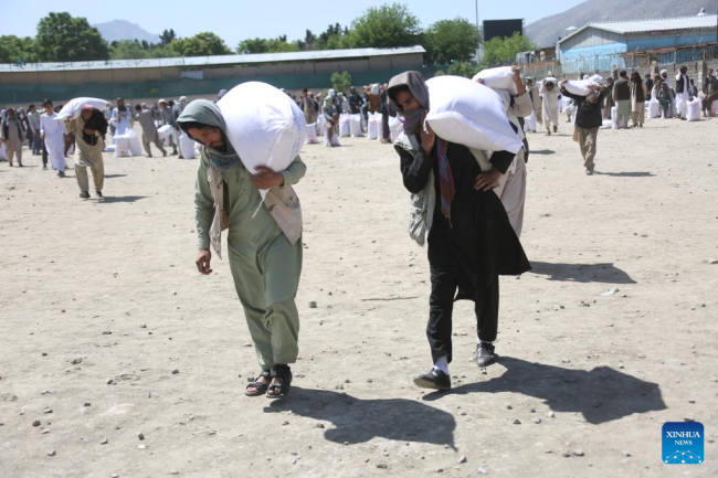 Άνθρωποι λαμβάνουν τρόφιμα που δώρισε η Κίνα στην Καμπούλ του Αφγανιστάν, στις 23 Απριλίου 2022. (Φωτογραφία/ Saifurahman Safi/Xinhua)