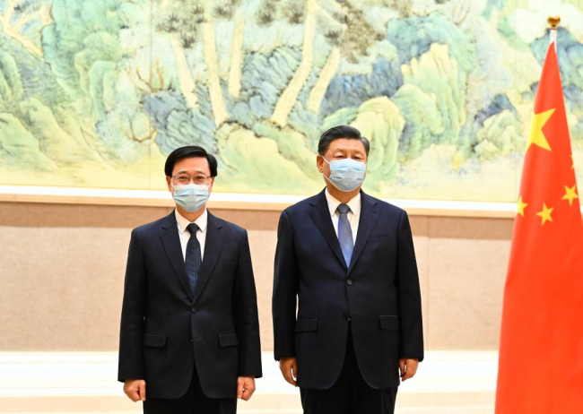 Ο Κινέζος Πρόεδρος Σι Τζινπίνγκ συναντά τον Τζον Λι, τον νεοδιορισθέντα για έκτη θητεία επικεφαλής της εκτελεστικής εξουσίας της Ειδικής Διοικητικής Περιοχής του Χονγκ Κονγκ (HKSAR), στο Πεκίνο στις 30 Μαΐου 2022. (φωτογραφία/Xinhua)
