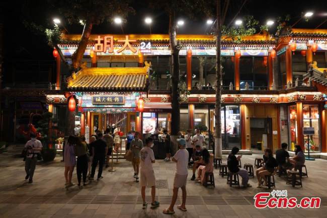 Οι πελάτες κάνουν ουρά για να σαρώσουν τους κώδικες υγείας και να εισέλθουν σε ένα εστιατόριο αμέσως μετά τα μεσάνυχτα, μετά από ένα μήνα όπου τα εστιατόρια μπορούσαν να λειτουργούν μέσω ηλεκτρονικής πλατφόρμας παραγγελίας, στις 6 Ιουνίου 2022. (Φωτογραφία: China News Service)