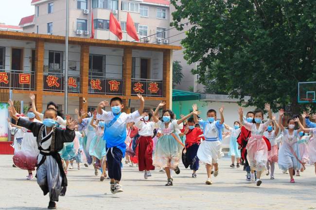 Μαθητές ντυμένοι με ‘χάνφου’ στο Δημοτικό Σχολείο Σιγουάνγκ στην περιοχή Τσιαοσί του Σιτζιατζουάνγκ, στην επαρχία Χεμπέι, ζητωκραυγάζουν. [Η φωτογραφία παρέχεται στο chinadaily.com.cn]