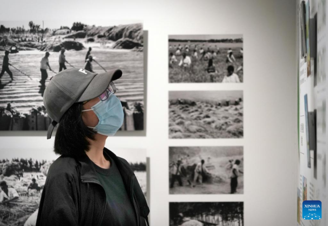 Ένας επισκέπτης βλέπει φωτογραφίες κατά τη διάρκεια μιας έκθεσης στο Κέντρο Τέχνης Ντανανπό της κομητείας Χιουγού στην πόλη Τζιαοζουό, στην επαρχία Χενάν της κεντρικής Κίνας. 30 Ιουλίου 2022. 
