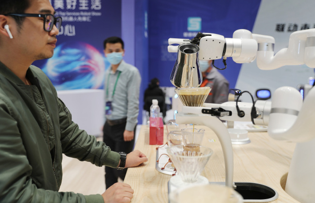 Un robot pregătește cafea pentru un vizitator.