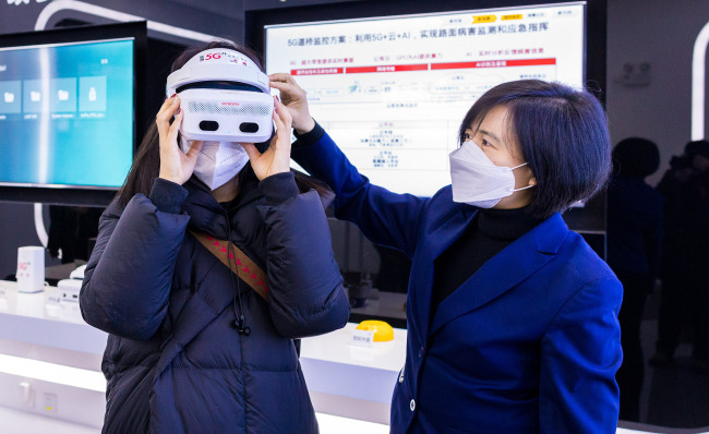 O vizitatoare poartă o cască de Realitatea Virtuală (VR) 5G.
